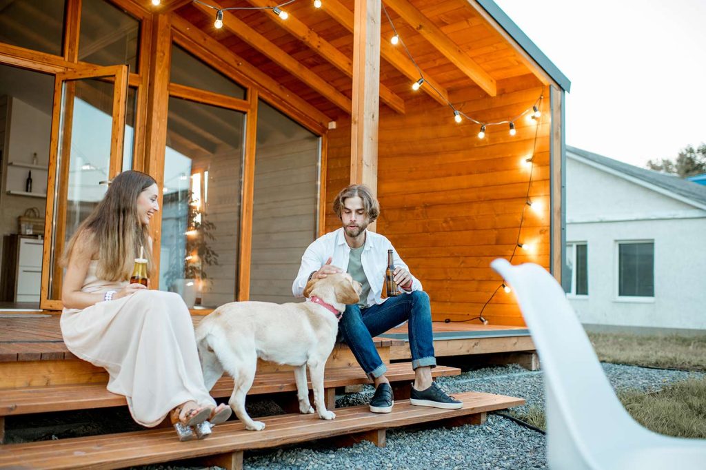 A couple sitting outside their tiny home